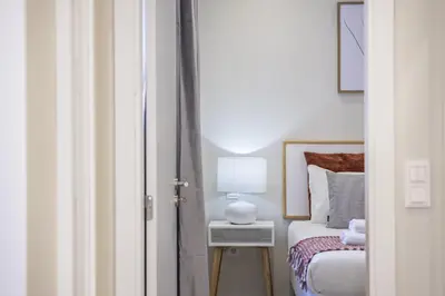 a bedroom with a bed and a lamp on a night stand at Casa da Oliveira by Homie in Caniço