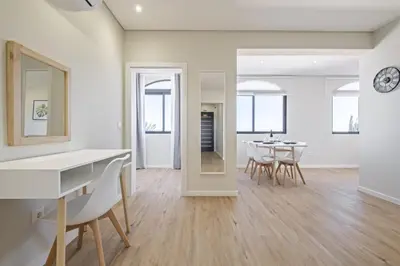 a dining room and living room with a table and chairs at Casa da Oliveira by Homie in Caniço