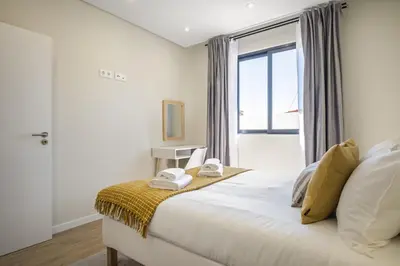 a bedroom with a large bed with a window at Casa da Oliveira by Homie in Caniço