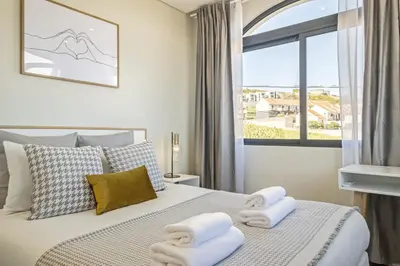 a bedroom with a bed with two towels on it at Casa da Oliveira by Homie in Caniço