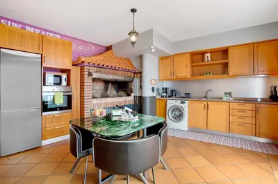 a kitchen with a table and chairs in a room at Sunparadise in Arco da Calheta