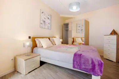 a bedroom with a large bed and a dresser at Sunparadise in Arco da Calheta