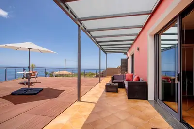 a patio with a view of the ocean at Sunparadise in Arco da Calheta