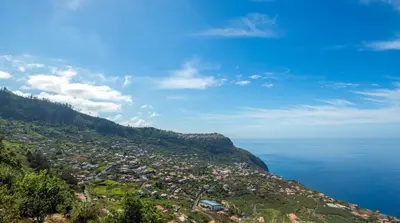 a town on a hill next to the ocean at Sunparadise in Arco da Calheta