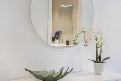 a bathroom with a mirror and a vase with flowers at Contemporary Residence B by Homie in Funchal