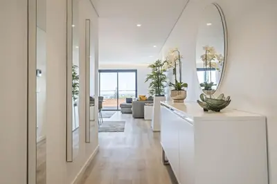 a living room with white walls and a mirror at Contemporary Residence C by Homie in Funchal