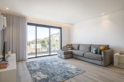 a living room with a couch and a large window at Contemporary Residence C by Homie in Funchal