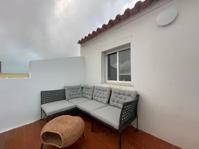 a living room with a couch and a window at Algarve Surf Hostel & Guest House in Raposeira