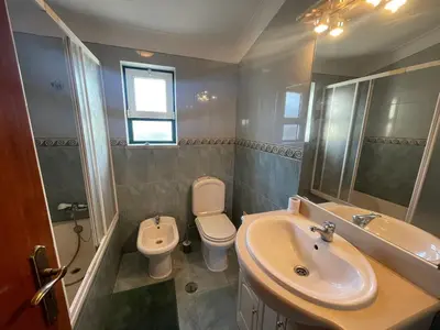 a bathroom with a sink and a toilet and a mirror at Algarve Surf Hostel & Guest House in Raposeira