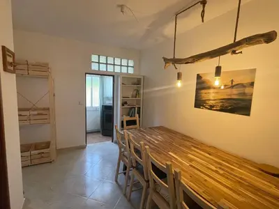 a dining room with a wooden table and chairs at Algarve Surf Hostel & Guest House in Raposeira