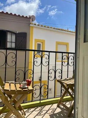 a balcony with a table and chairs on a building at Algarve Surf Hostel & Guest House in Raposeira