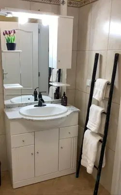a bathroom with a white sink and a mirror at Casa do Amigo in Seixal