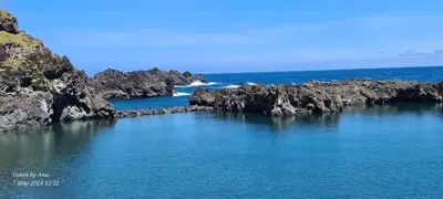 a large body of water with rocks in the ocean at Casa do Amigo in Seixal