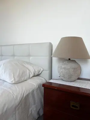 a lamp sitting on a dresser next to a bed at Home Away From Home in Funchal