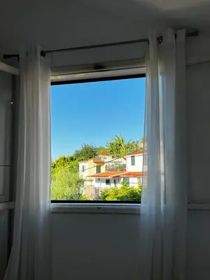 a window with a view of a house at Home Away From Home in Funchal