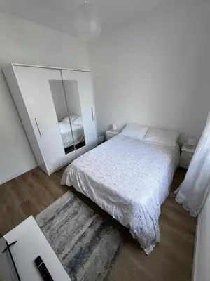 a white bedroom with a bed and a mirror at Home Away From Home in Funchal