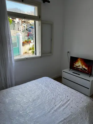 a bedroom with a bed and a tv and a window at Home Away From Home in Funchal