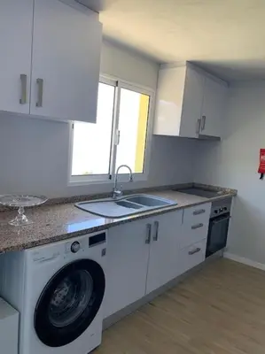 a kitchen with a washing machine and a sink at Casa Jardim Panoramic View in Estreito da Calheta