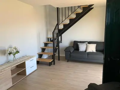 a living room with a couch and a spiral staircase at Casa Jardim Panoramic View in Estreito da Calheta