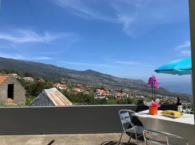 a table and chairs on a balcony with a view at Casa Jardim Panoramic View in Estreito da Calheta