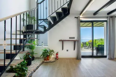 an open living room with stairs and potted plants at Refugio Do Lourinho in Calheta