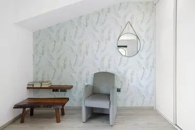 a living room with a chair and a mirror at Refugio Do Lourinho in Calheta