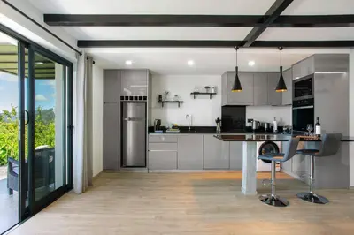a kitchen with stainless steel appliances and a table at Refugio Do Lourinho in Calheta