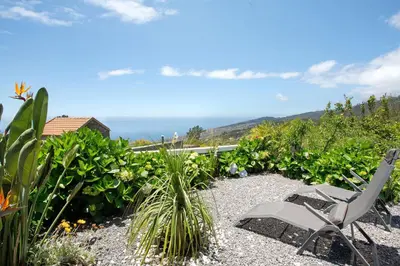a pair of chairs sitting in a garden at Refugio Do Lourinho in Calheta