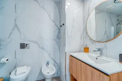a bathroom with a sink and a toilet and a mirror at The Pink Palm Apartment by Amazing Madeira in Funchal
