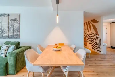 a dining room with a wooden table and chairs at The Pink Palm Apartment by Amazing Madeira in Funchal