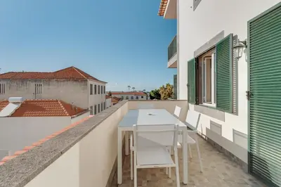 a balcony with a table and chairs on a building at Old Town Apartment in Funchal
