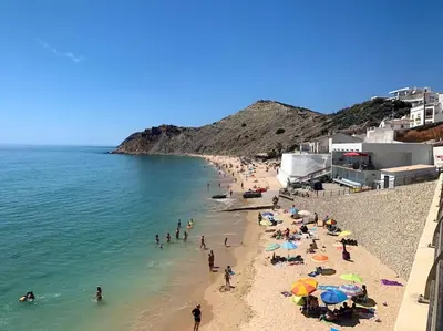 a group of people on a beach in the water at Apartamento Caravela em Burgau - NEW LISTING in Burgau