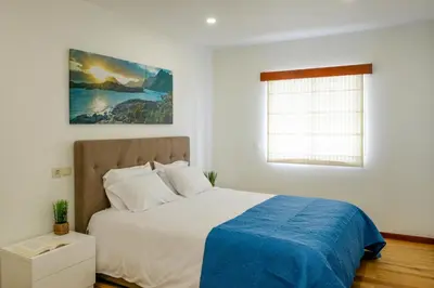 a bedroom with a large bed with white pillows at Casa do Simão Gaula in Santa Cruz