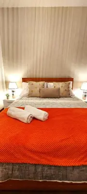 a bedroom with a large bed with an orange blanket at Villa City in Funchal