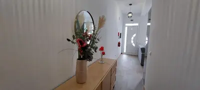 a vase with flowers on a dresser in a hallway at Villa City in Funchal