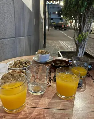 a wooden table with glasses of orange juice and nuts at Apartment in Camara de Lobos not shared in Câmara de Lobos