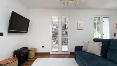 a living room with a blue couch and a flat screen tv at Stonewood Valley by LovelyStay in Curral das Freiras