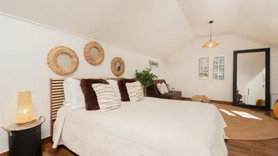 a bedroom with a white bed and mirrors on the wall at Stonewood Valley by LovelyStay in Curral das Freiras