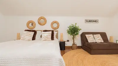 a bedroom with a large bed and a chair at Stonewood Valley by LovelyStay in Curral das Freiras