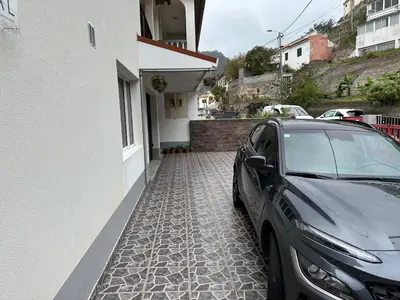 a black car parked next to a building at House Lourdes & Manuel in Machico