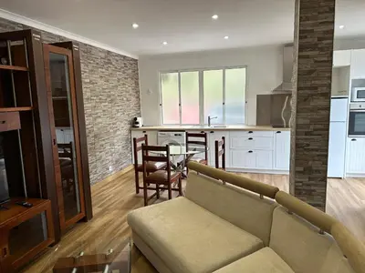 a living room and kitchen with a couch and a table at House Lourdes & Manuel in Machico