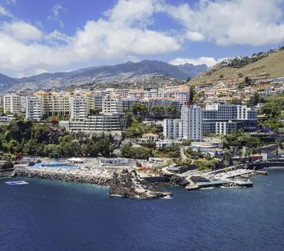 a city with buildings and boats in the water at Apartamento do Mar e Lua in Funchal