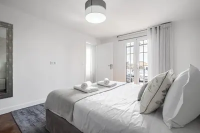 a white bedroom with a bed with two towels on it at City Haven by Homie in Funchal