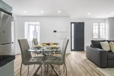 a kitchen and living room with a table and chairs at City Haven by Homie in Funchal