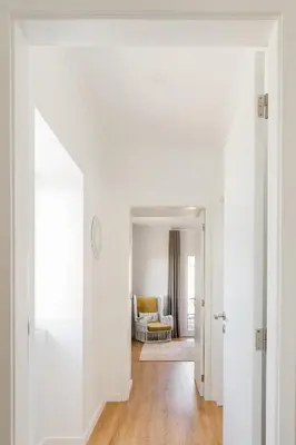 a hallway with white walls and a living room at Casa Ti'Rosa in Caniço
