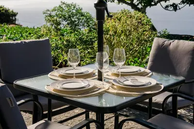 a table with plates and wine glasses on it at Casa Ti'Rosa in Caniço