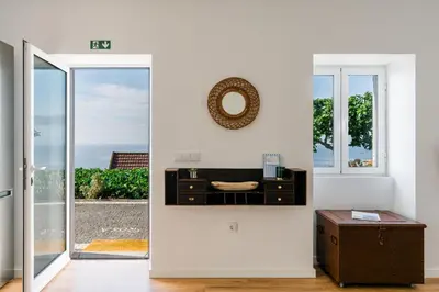 a white room with a table and a mirror on the wall at Casa Ti'Rosa in Caniço