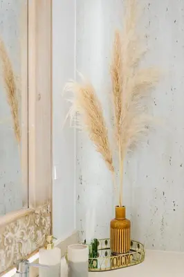 a vase with feathers in it sitting on a counter at Casa Ti'Rosa in Caniço