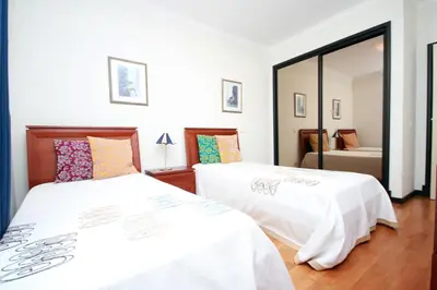 a bedroom with two beds and a mirror at Forum Apartment by HR Madeira in Funchal