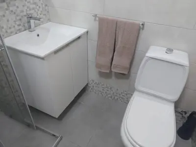 a white bathroom with a toilet and a sink at Angela Beach Place in Vila Baleira